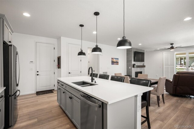 9157 Rio Lado St, Littleton, CO 80125 - kitchen with a sink, appliances with stainless steel finishes, gray cabinetry, light wood finished floors, and recessed lighting