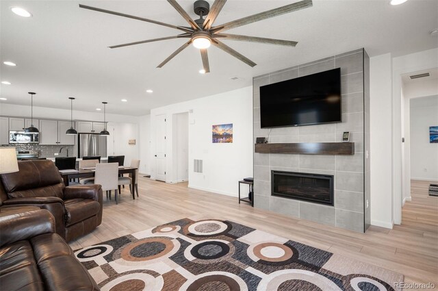 9157 Rio Lado St, Littleton, CO 80125 - living area with recessed lighting, light wood-type flooring, a ceiling fan, baseboards, and a fireplace