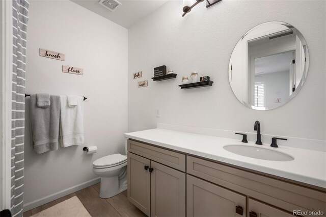 9157 Rio Lado St, Littleton, CO 80125 - bathroom with vanity, toilet, and wood finished floors