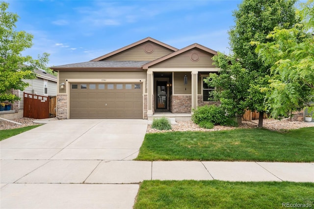 15061 W 70th Ave, Arvada, CO 80007 - view of front of home with a garage, concrete driveway, stone siding, and covered porch