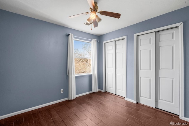 unfurnished bedroom featuring baseboards, a ceiling fan, and dark wood finished floors