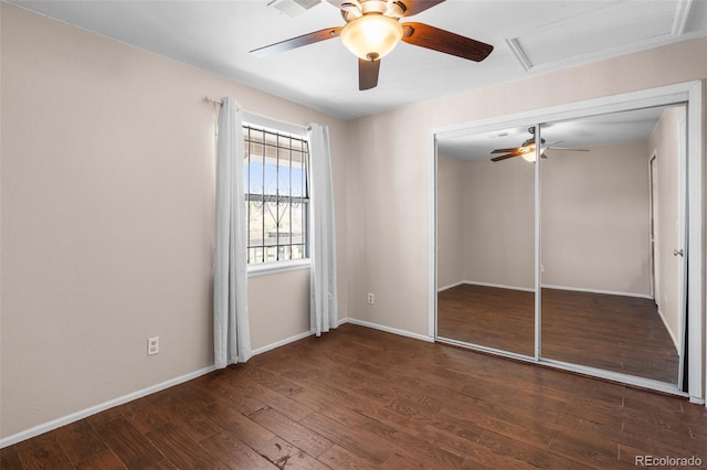 unfurnished bedroom featuring baseboards, a ceiling fan, a closet, and wood finished floors