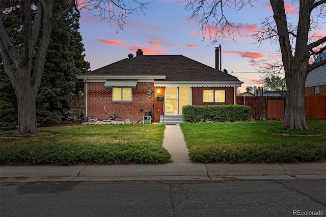 bungalow-style home with brick siding and a chimney