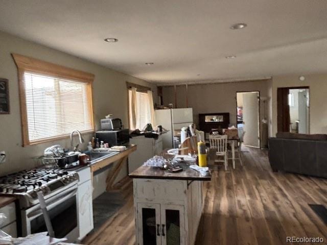 9707 County Lane 22.5, Sugar City, CO 81076 - kitchen with gas stove, freestanding refrigerator, wood finished floors, and a sink