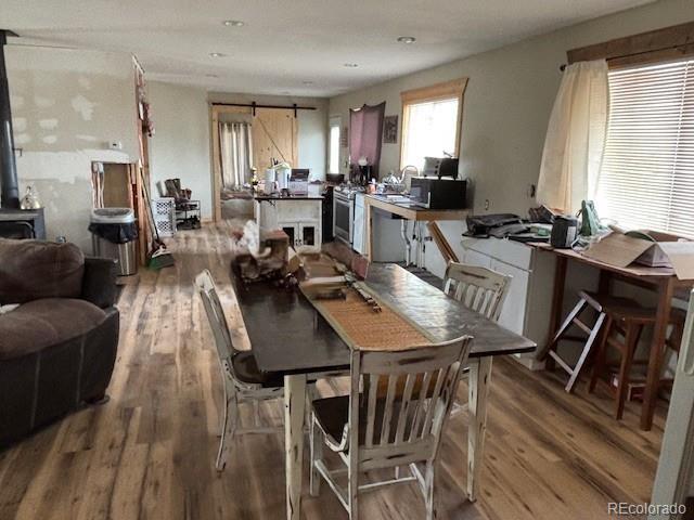 9707 County Lane 22.5, Sugar City, CO 81076 - dining room featuring wood finished floors and a wood stove