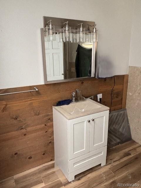 9707 County Lane 22.5, Sugar City, CO 81076 - bathroom with vanity, wood finished floors, and a wainscoted wall