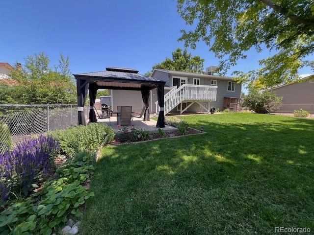 12235 Garfield Pl, Thornton, CO 80241 - rear view of house featuring a gazebo, a patio area, stairway, and a wooden deck