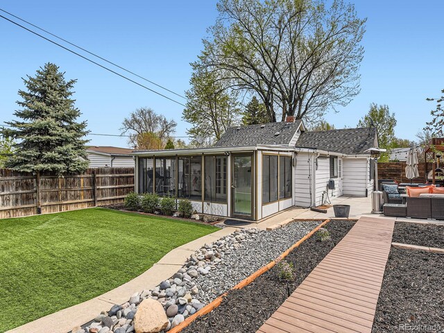 4747 S Elati St, Englewood, CO 80110 - back of property featuring a sunroom, an outdoor hangout area, a fenced backyard, a shingled roof, and a patio