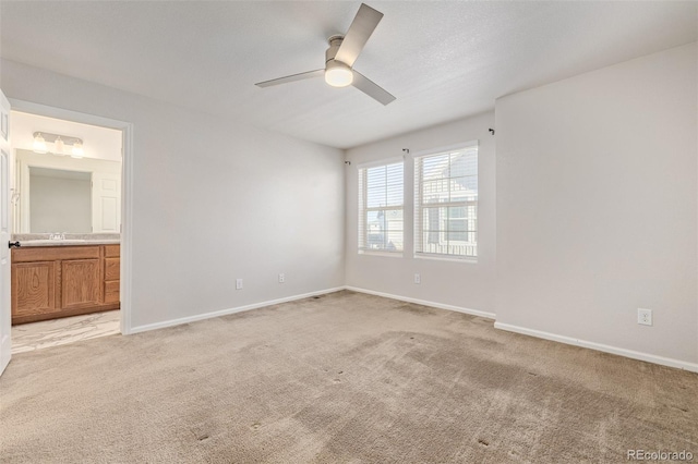 carpeted spare room with ceiling fan and sink