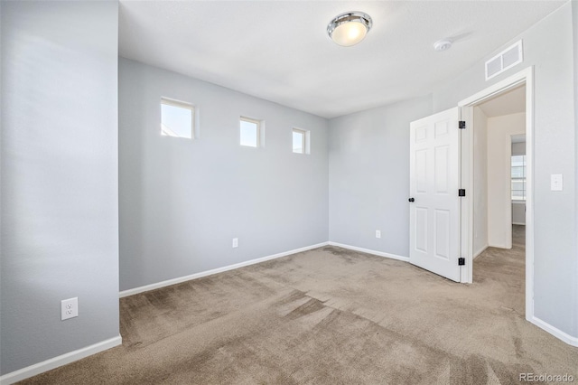 carpeted spare room featuring a wealth of natural light