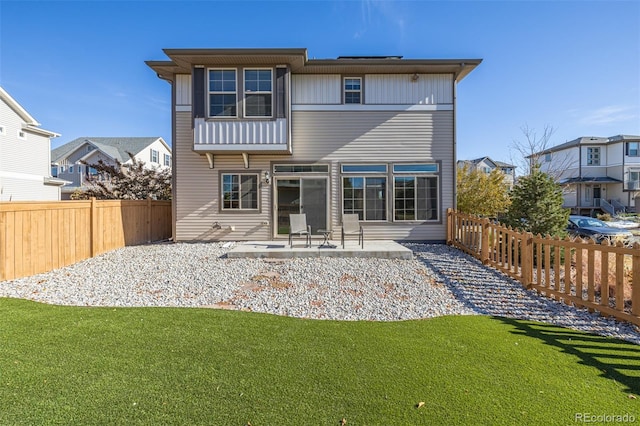 rear view of house with a yard and a patio