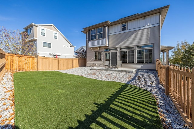 back of house featuring a lawn and a patio area