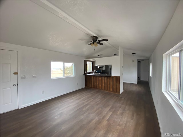 unfurnished living room featuring dark wood-type flooring, lofted ceiling with beams, and ceiling fan