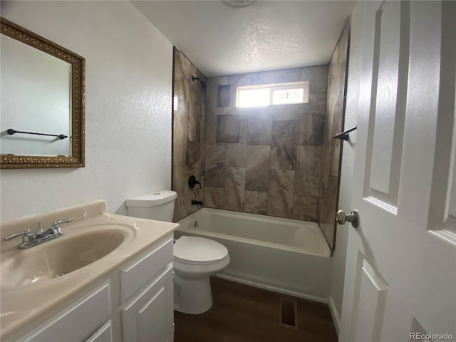 full bathroom featuring vanity, tiled shower / bath combo, toilet, and hardwood / wood-style flooring