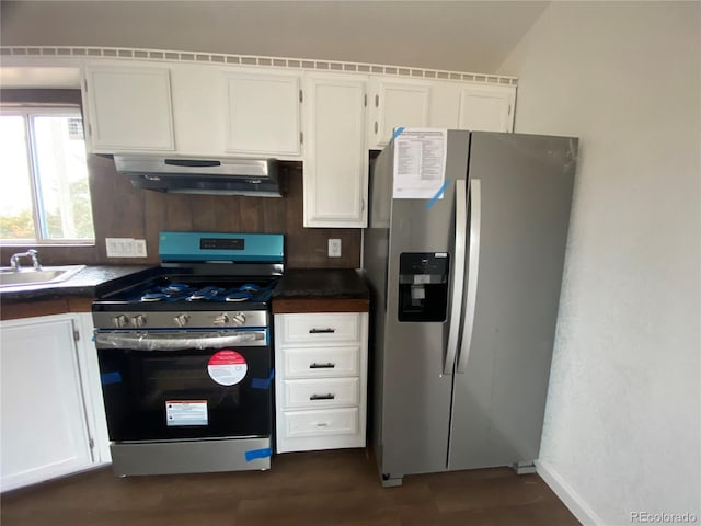 kitchen with stainless steel appliances, extractor fan, and white cabinetry