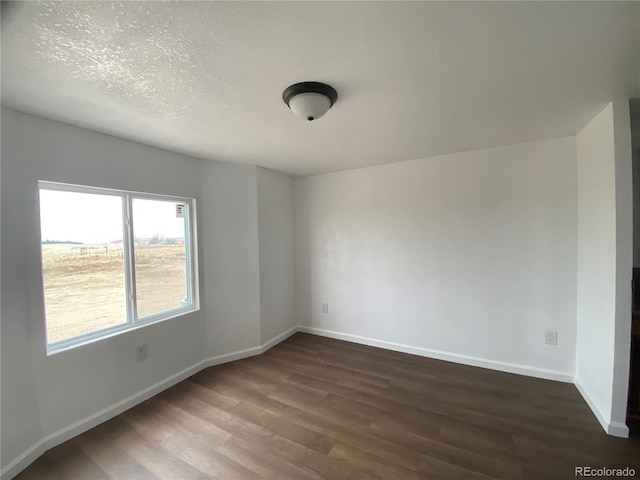 unfurnished room with a textured ceiling and dark hardwood / wood-style flooring