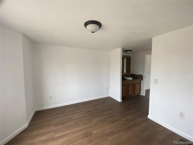 empty room with dark wood-type flooring and sink