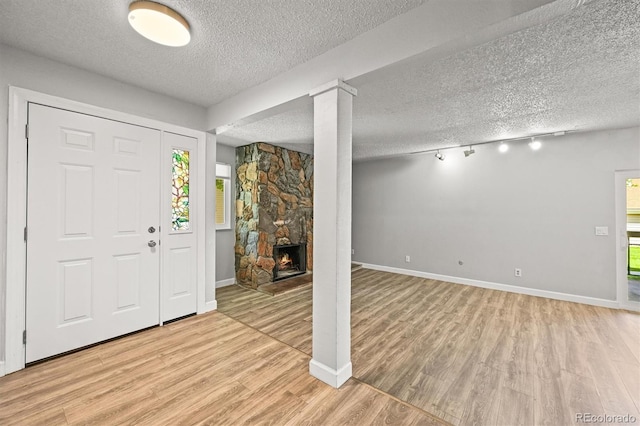 2678 S Xanadu Way Unit C, Aurora, CO 80014 - foyer featuring a textured ceiling, light wood finished floors, a fireplace, and track lighting