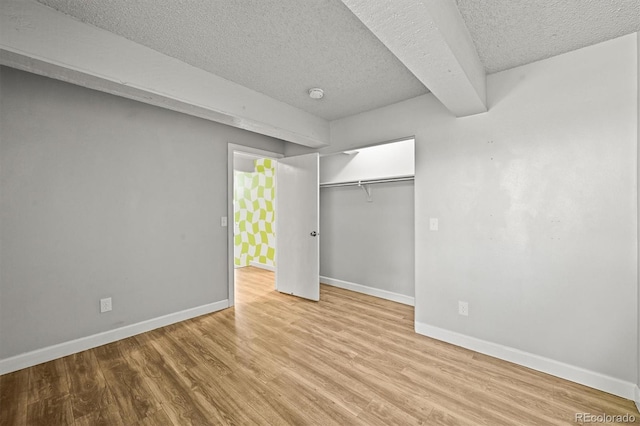 2678 S Xanadu Way Unit C, Aurora, CO 80014 - unfurnished bedroom featuring a textured ceiling, wood finished floors, and a closet
