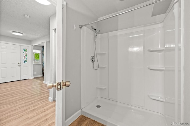 2678 S Xanadu Way Unit C, Aurora, CO 80014 - full bathroom with wood finished floors, a shower, and a textured ceiling
