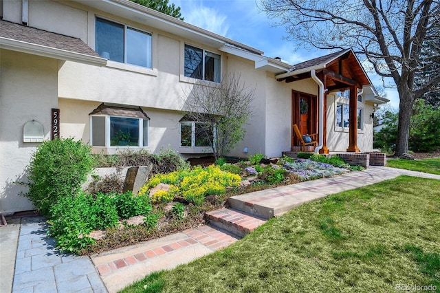 view of front of home with stucco siding and a front lawn