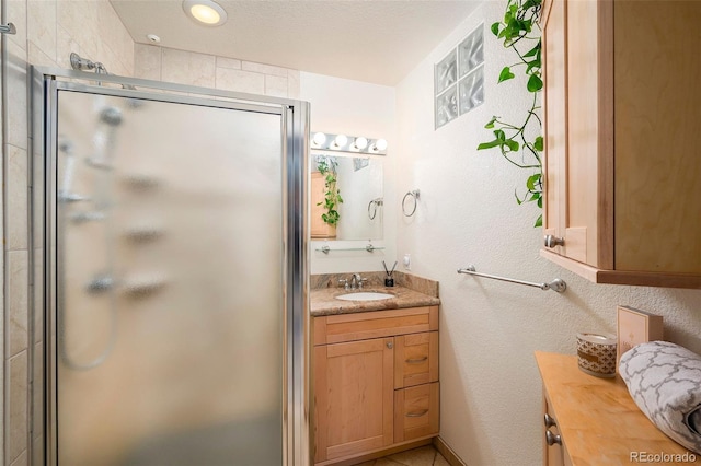 full bathroom with a shower stall and vanity