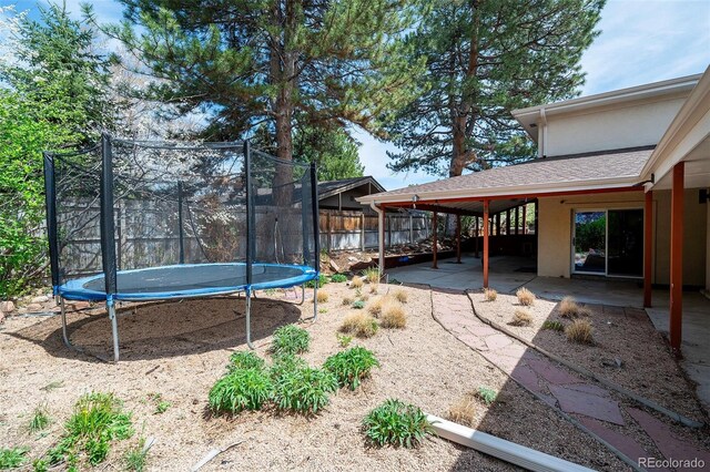 5925 E Fair Ave, Centennial, CO 80111 - view of yard featuring a trampoline, a patio, and fence