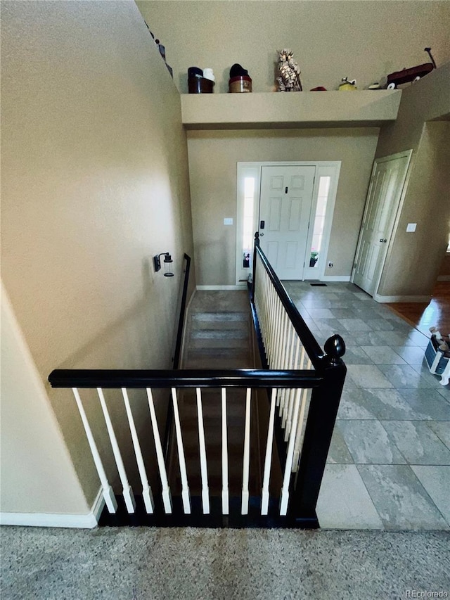 690 Antelope Dr, Bennett, CO 80102 - stairway featuring baseboards and stone tile floors