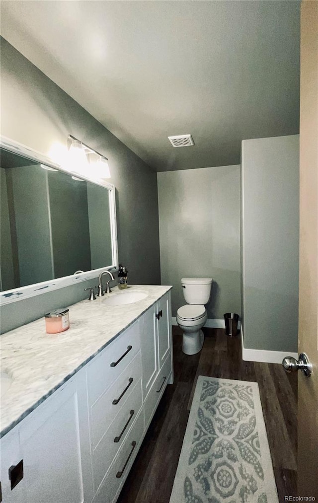 690 Antelope Dr, Bennett, CO 80102 - bathroom with wood finished floors, vanity, toilet, and baseboards