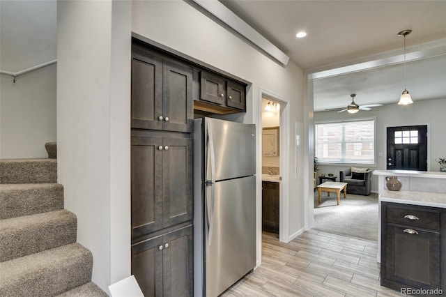 304 Barnwood Dr, Buena Vista, CO 81211 - kitchen with freestanding refrigerator, open floor plan, dark brown cabinets, ceiling fan, and light wood-style flooring