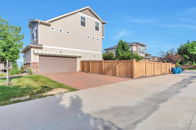 18096 E 104th Way, Commerce City, CO 80022 - view of side of home featuring decorative driveway, stone siding, and an attached garage