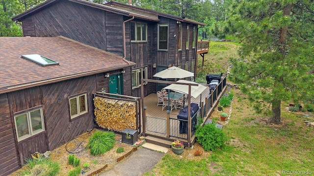9745 Hilldale Dr, Morrison, CO 80465 - rear view of house with a wooden deck, roof with shingles, and outdoor dining space