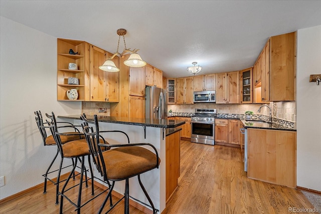 9745 Hilldale Dr, Morrison, CO 80465 - kitchen featuring stainless steel appliances, a peninsula, a breakfast bar, and backsplash