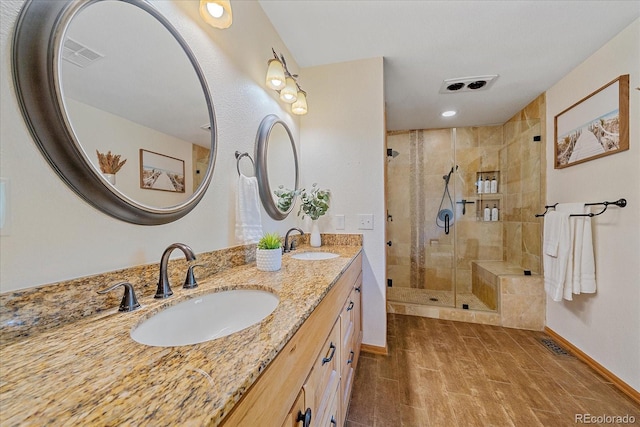 9745 Hilldale Dr, Morrison, CO 80465 - bathroom featuring double vanity, a stall shower, wood finished floors, and recessed lighting