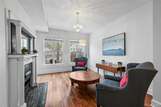 1717 E 22nd Ave, Denver, CO 80205 - sitting room featuring baseboards, a chandelier, wood finished floors, and a premium fireplace