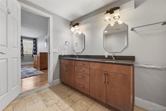 1717 E 22nd Ave, Denver, CO 80205 - full bath with double vanity, baseboards, and a sink