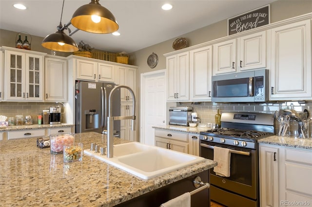 3560 Zane Gray Loop, Parker, CO 80138 - kitchen featuring stainless steel appliances, tasteful backsplash, hanging light fixtures, glass insert cabinets, and white cabinets