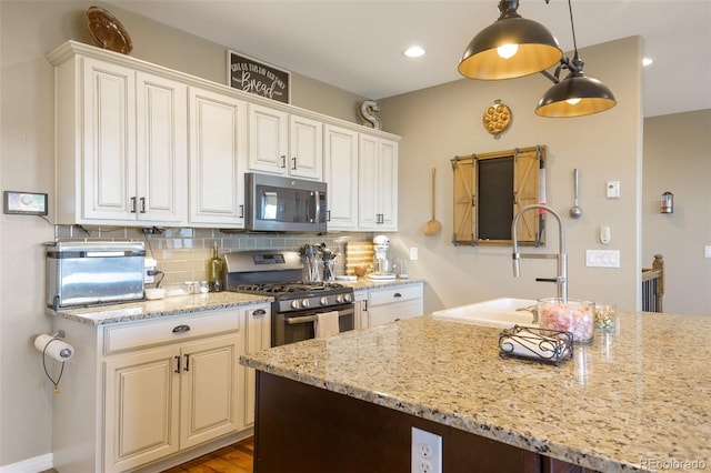 3560 Zane Gray Loop, Parker, CO 80138 - kitchen featuring appliances with stainless steel finishes, decorative backsplash, light stone counters, decorative light fixtures, and white cabinets