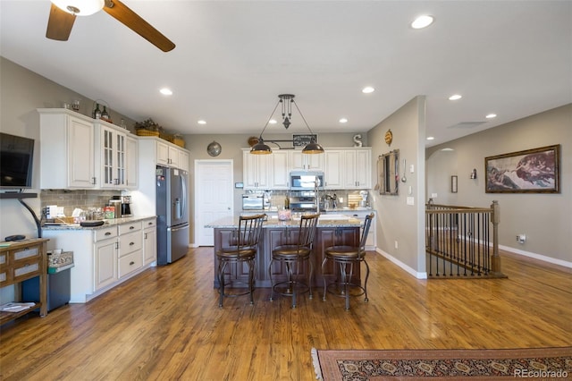 3560 Zane Gray Loop, Parker, CO 80138 - kitchen featuring decorative backsplash, stainless steel appliances, white cabinetry, wood finished floors, and recessed lighting