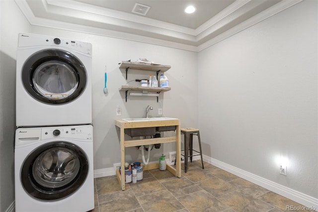 3560 Zane Gray Loop, Parker, CO 80138 - laundry room featuring stacked washer and clothes dryer, crown molding, stone finish flooring, and recessed lighting