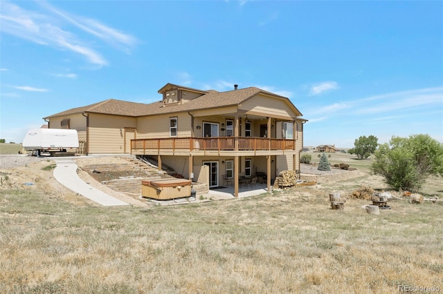 3560 Zane Gray Loop, Parker, CO 80138 - back of property featuring a hot tub, a patio, roof with shingles, a wooden deck, and a lawn