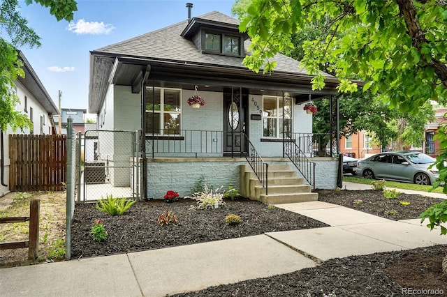 4059 Quivas St, Denver, CO 80211 - bungalow-style home with covered porch, roof with shingles, and brick siding