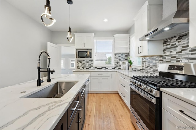 4059 Quivas St, Denver, CO 80211 - kitchen featuring stainless steel gas stove, wall chimney exhaust hood, black microwave, light wood-style flooring, and white cabinetry