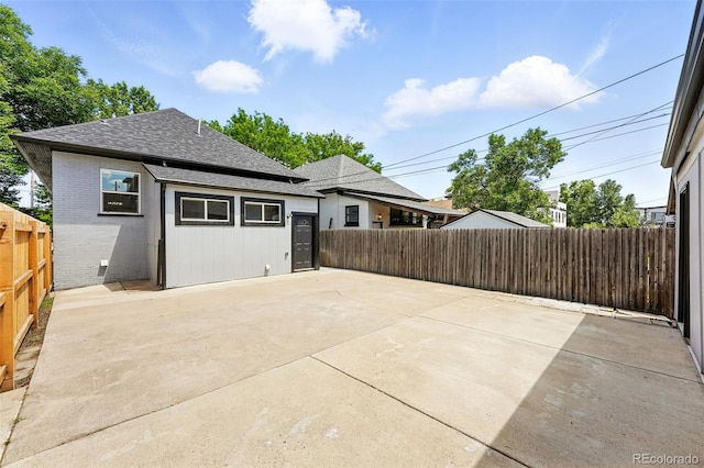 4059 Quivas St, Denver, CO 80211 - back of property featuring a patio, a shingled roof, brick siding, and a fenced backyard