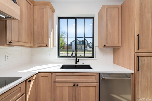 kitchen featuring light brown cabinetry, backsplash, light countertops, dishwasher, and a sink