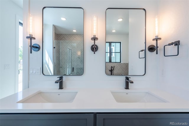 full bath featuring double vanity, a shower stall, and a sink