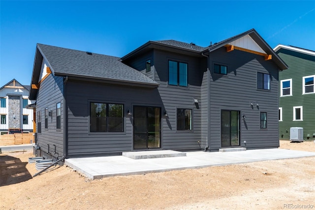 rear view of property with cooling unit and a patio
