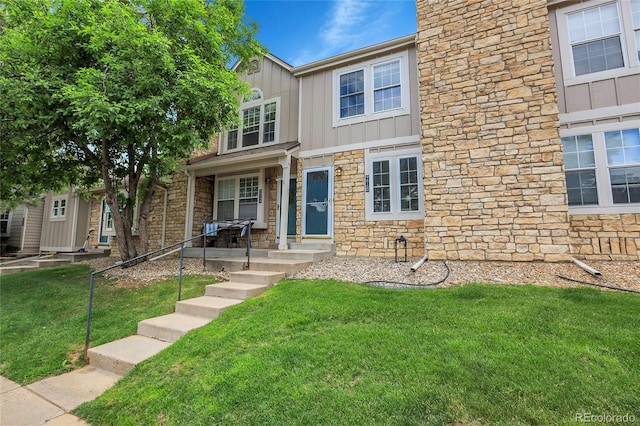 9615 W Chatfield Ave Unit C, Littleton, CO 80128 - view of front facade featuring stone siding, board and batten siding, and a front lawn