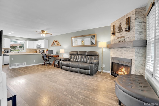 9615 W Chatfield Ave Unit C, Littleton, CO 80128 - living area featuring light wood finished floors, a ceiling fan, a fireplace, and recessed lighting