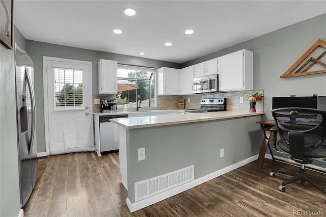 9615 W Chatfield Ave Unit C, Littleton, CO 80128 - kitchen with appliances with stainless steel finishes, light countertops, dark wood-style floors, a peninsula, and recessed lighting